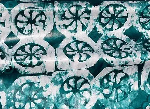 Bazin teinté vert profond, motif de rosaces claires.