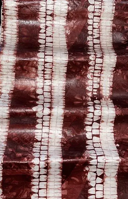 Bazin teinté bordeaux, bandes verticales écrues obtenues par ligature.