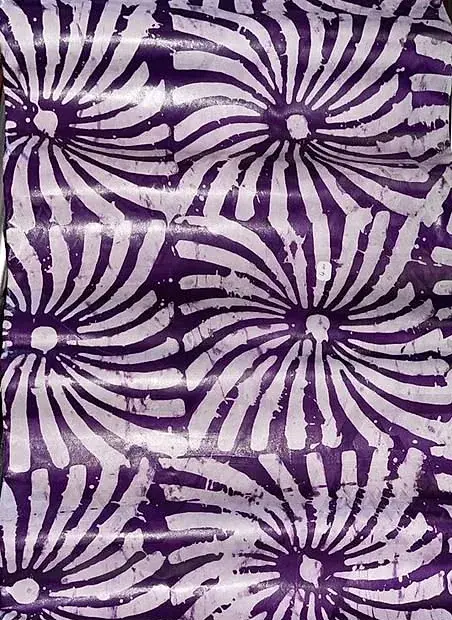Bazin teinté parme, rosaces claires en spirale sur fond soutenu.