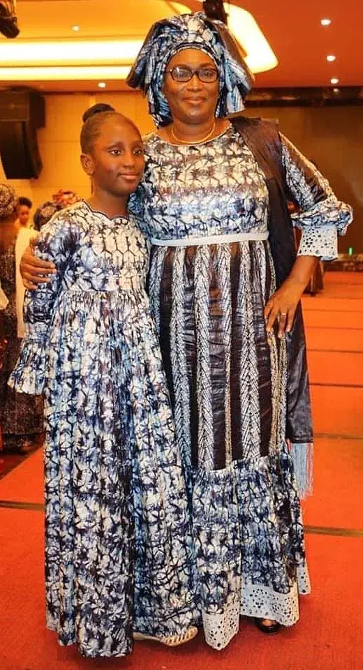 Une femme et une jeune fille en tenues assorties de bazin teinté indigo.